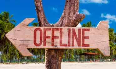 Flèche en bois avec le mot 'offline' ecrit dessus - plage en arrière-plan