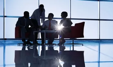 Groupe discutant autour d'une table dans un bureau moderne.