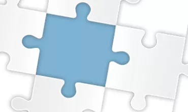 Pièce de puzzle bleue au centre d'autres pièces blanches.