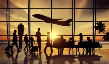 Silhouettes de passagers à l'aéroport avec avion au crépuscule.