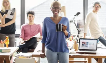 Groupe de personnes dans un bureau, une personne tient une tasse