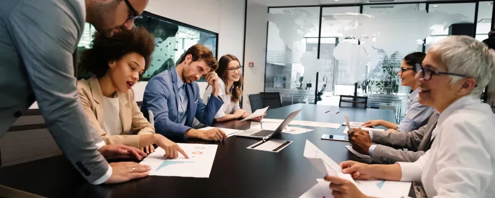 Réunion d'équipe autour d'une table avec des documents.