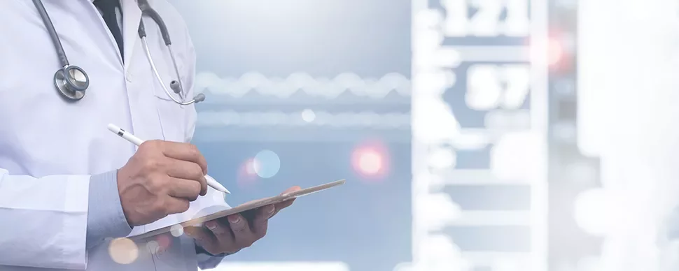 Médecin en blouse blanche écrivant sur une tablette.