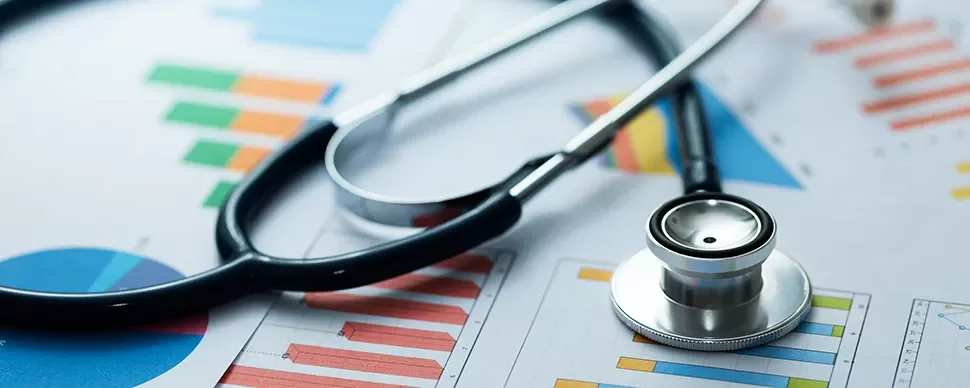 Stéthoscope posé sur des graphiques colorés représentant des données médicales.