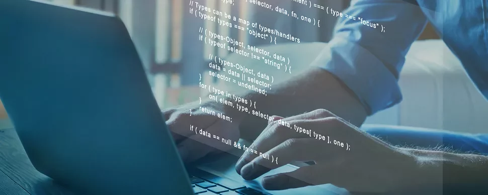 Une personne tape du code sur un ordinateur portable.