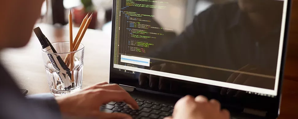 Personne tapant du code sur un ordinateur portable.