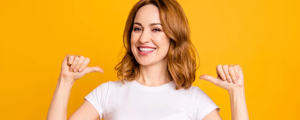 Personne souriante en t-shirt blanc sur fond jaune.