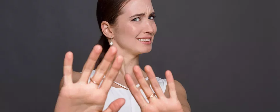 Personne levant les mains avec une expression incertaine.