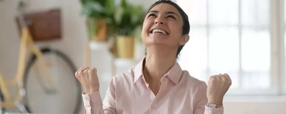 Personne souriante, les poings levés avec joie.