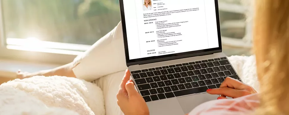 Personne utilisant un ordinateur portable pour lire un CV.