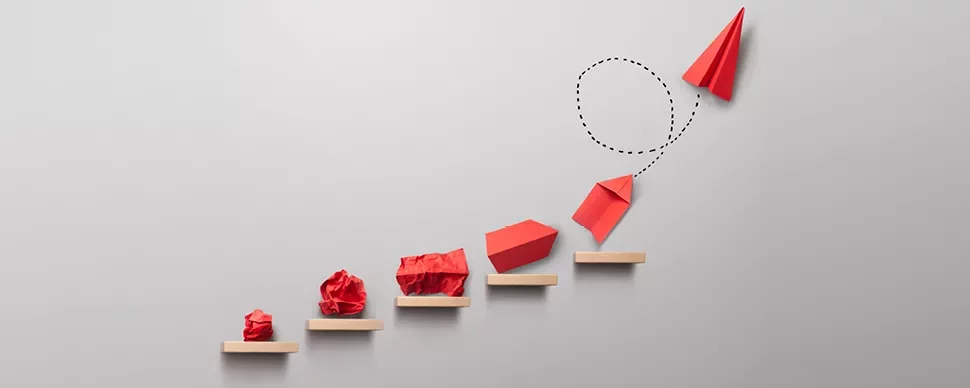 Progression d'objets en papier rouge sur des marches.
