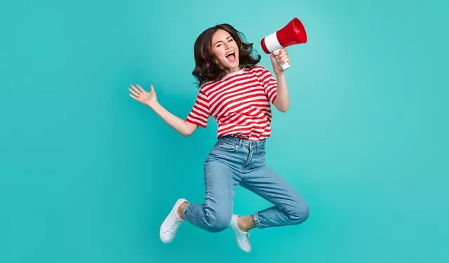 Personne sautant avec un mégaphone sur fond turquoise.
