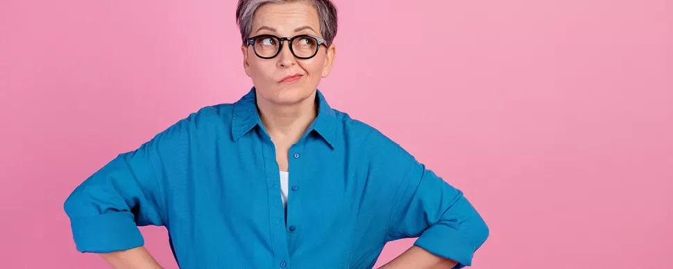 Personne avec des lunettes sur fond rose.