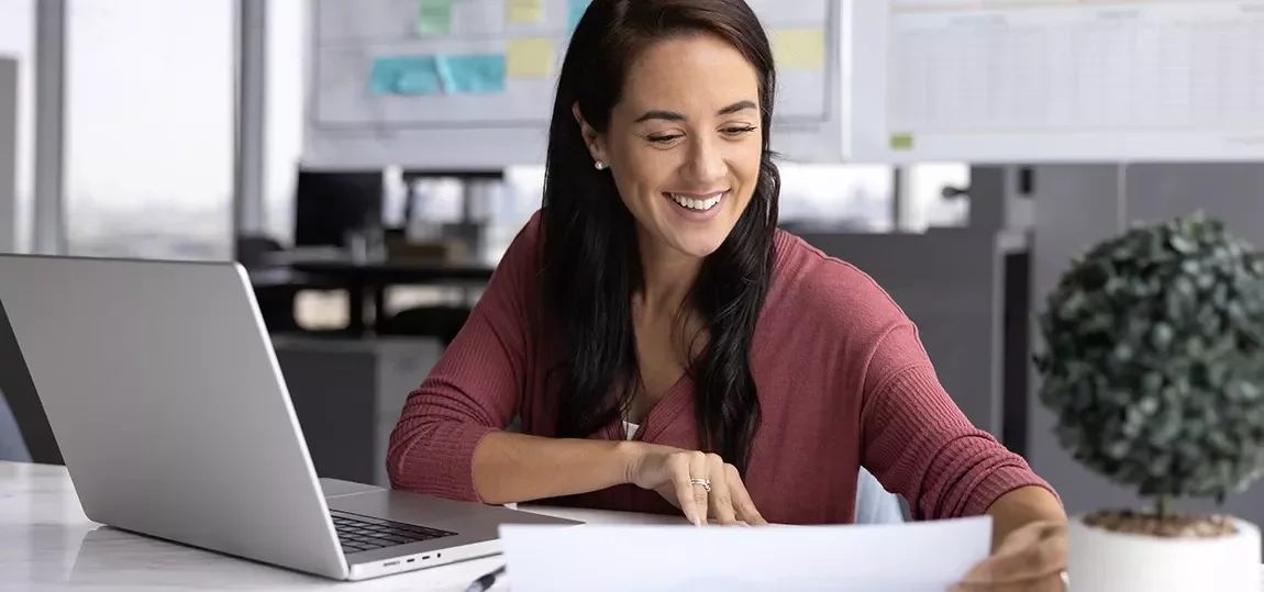 Femme souriante travaillant devant un ordinateur 