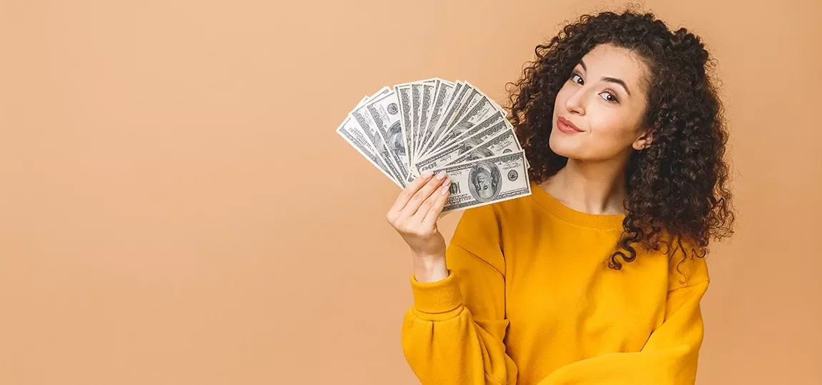 Femme tenant plusieurs billets de banque dans la main