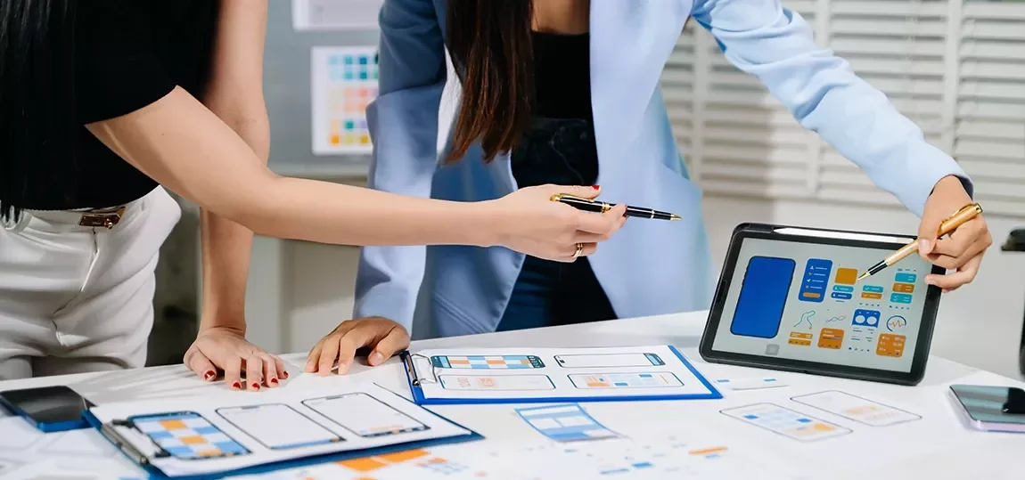 Designer devant une tablette graphique ou écran avec maquettes d'interface / ambiance créative