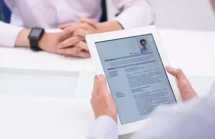 Entretien d'embauche avec un document sur tablette.