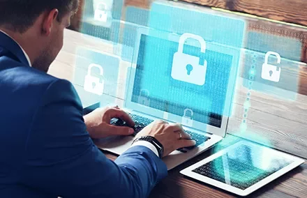 Personne utilisant un ordinateur portable avec des icônes de sécurité sur l'écran.