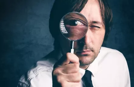 Personne regardant à travers une loupe.