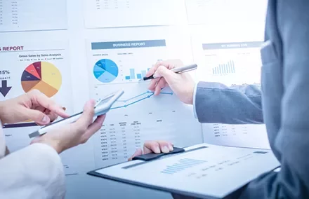 Discussion autour de graphiques financiers dans un bureau.