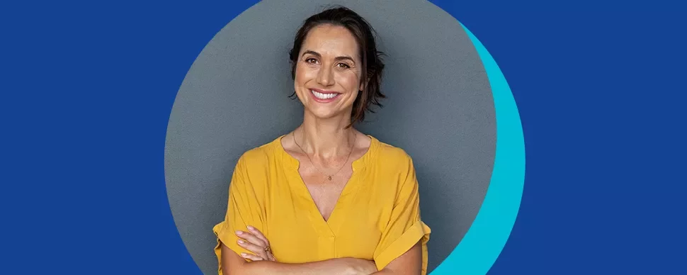 Personne souriante en chemise jaune devant un fond bleu.