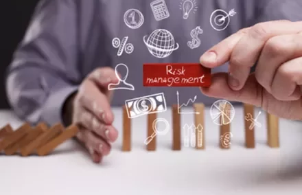 Illustration de gestion des risques avec dominos et icônes économiques.