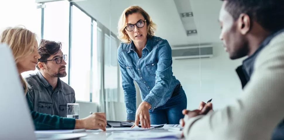 Personnes discutant autour d'une table de réunion.