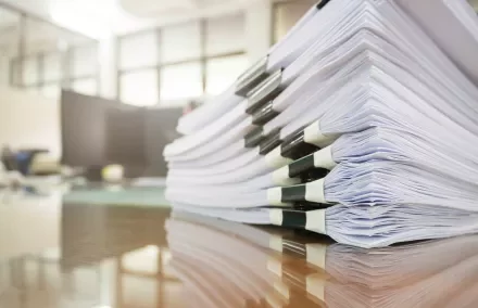 Pile de documents empilés sur une table en bois.