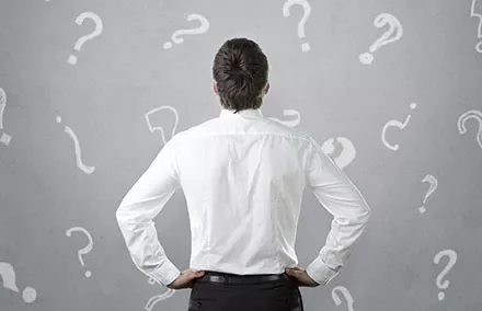 Personne en chemise blanche de dos, entourée de points d'interrogation.